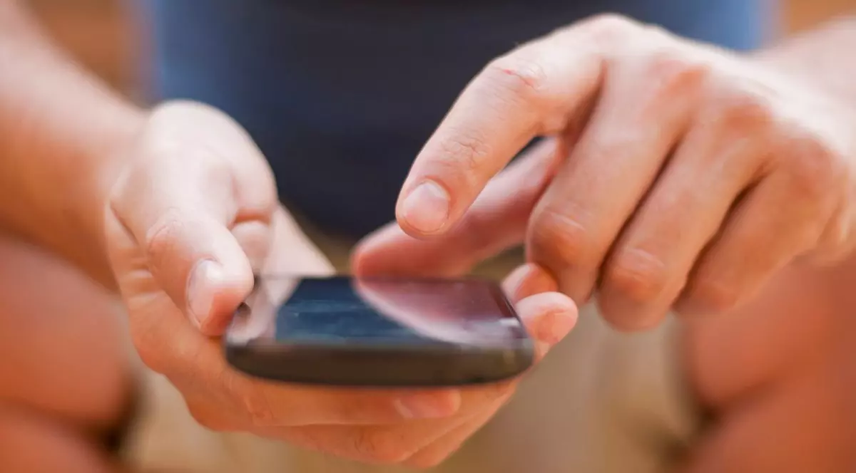 bărbat care scrie un mesaj pe telefonul mobil