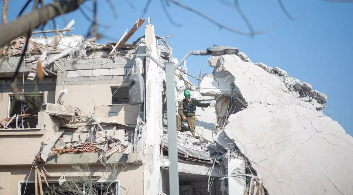 Muncitor israelian, cautand victime intr-o clădire distrusă după ce o rachetă iraniană a lovit o regiune din Israel