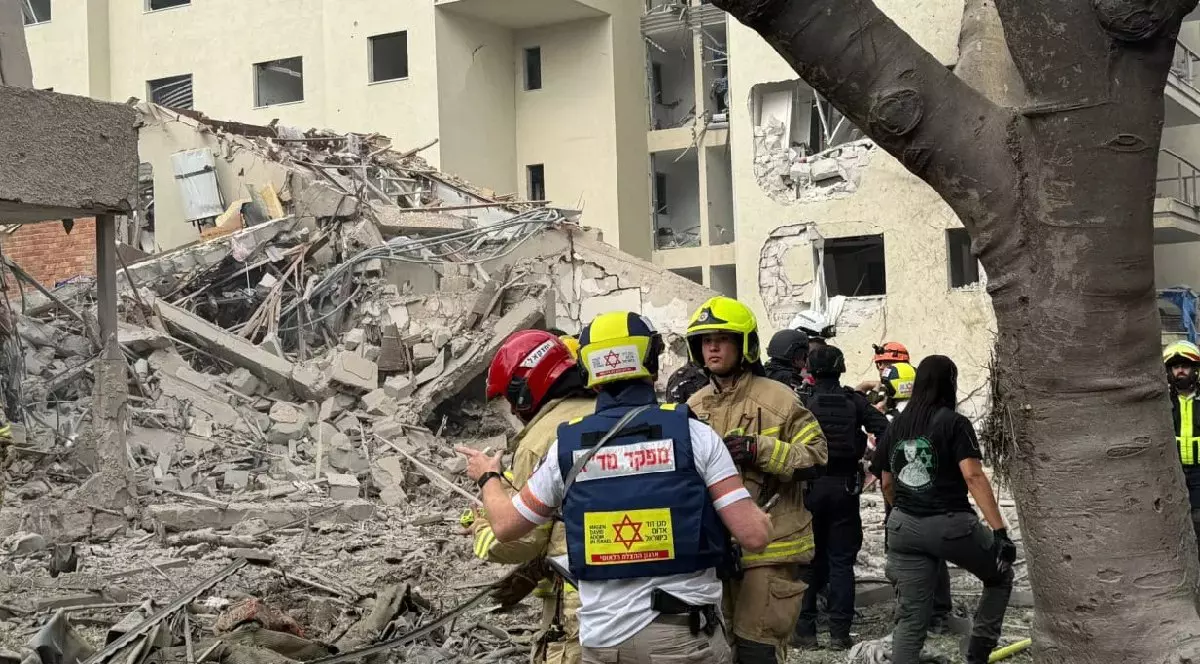 Mai mulți pompieri israelieni în fața unei clădiri prăbușite, după atacul Iranului ca urmare a loviturilor SUA- 22 iunie 2025