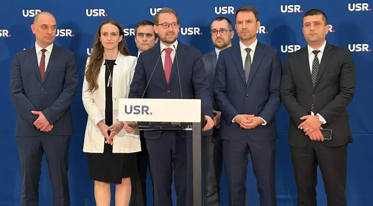 Dominic Fritz vorbește la pupitru în mijlocul colegilor de partid