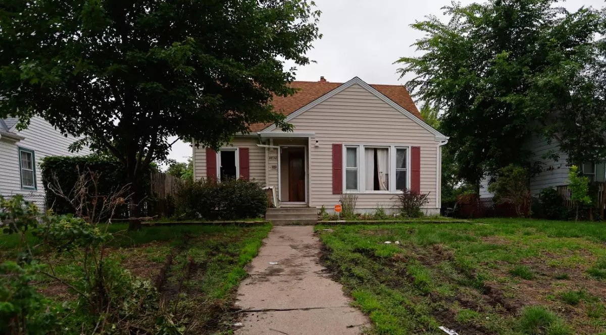 Imagine cu o casă, cu copaci in stanga si dreapta, o poteca care duce pana la veranda, si iarba verde