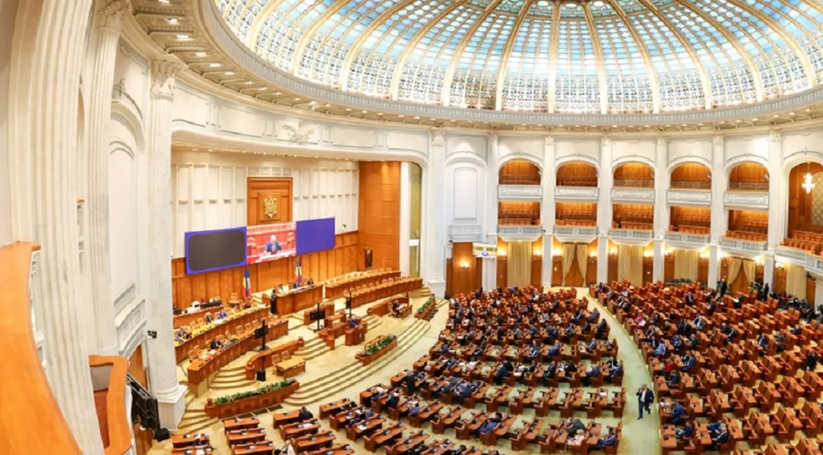 Imagine panoramica cu sala plenului Camerei Deputaților din Palatul Parlamentului din București, o sală mare, semicirculară, cu sute de locuri pentru parlamentari, dotată cu bănci din lemn și scaune tapițate