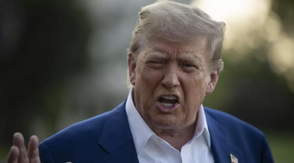 Donald Trump, îmbrăcat în costum albastru închis și cămașă albă