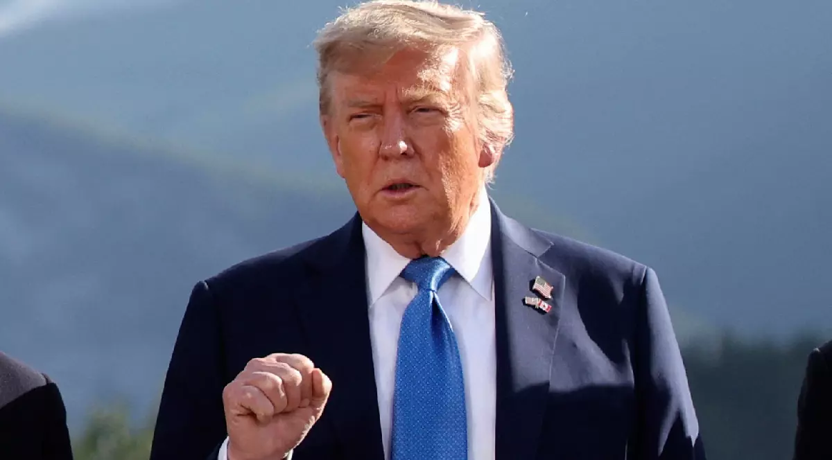 Donald Trump îmbrăcat într-un costum negru, cu o cămașă albă și o cravată albastră, ridicând pumnul în aer, în timpul unui discurs