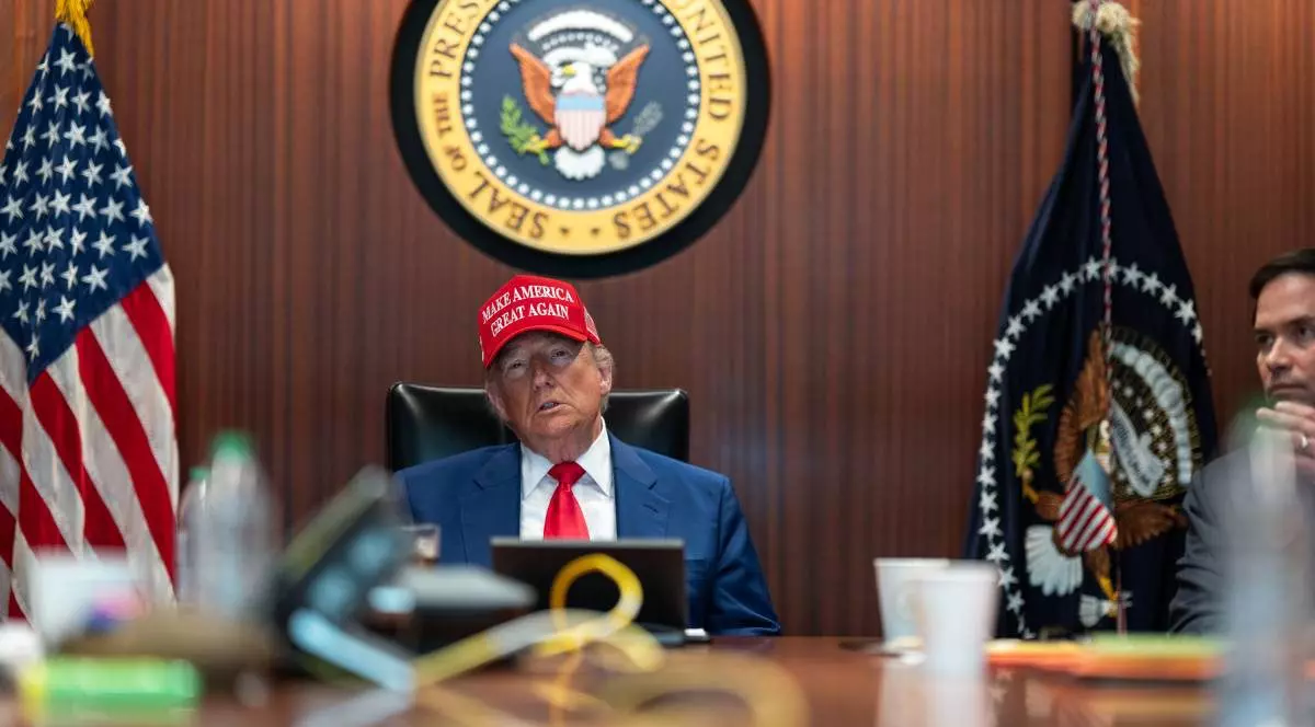 Donald Trump surprins în capul mesei, în Situation Room, stând serios și purtând o șapcă roșie cu sloganul „Make America Great Again”. Fotografia a fost realizată pe 21 iunie 2025