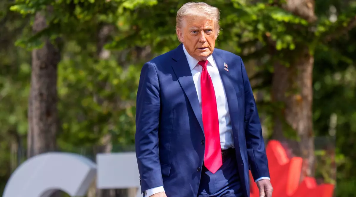 Donald Trump surprins la summitul G7. Poartă un costum albastru, o cămașă de aceeași culoare și o cravată roșie