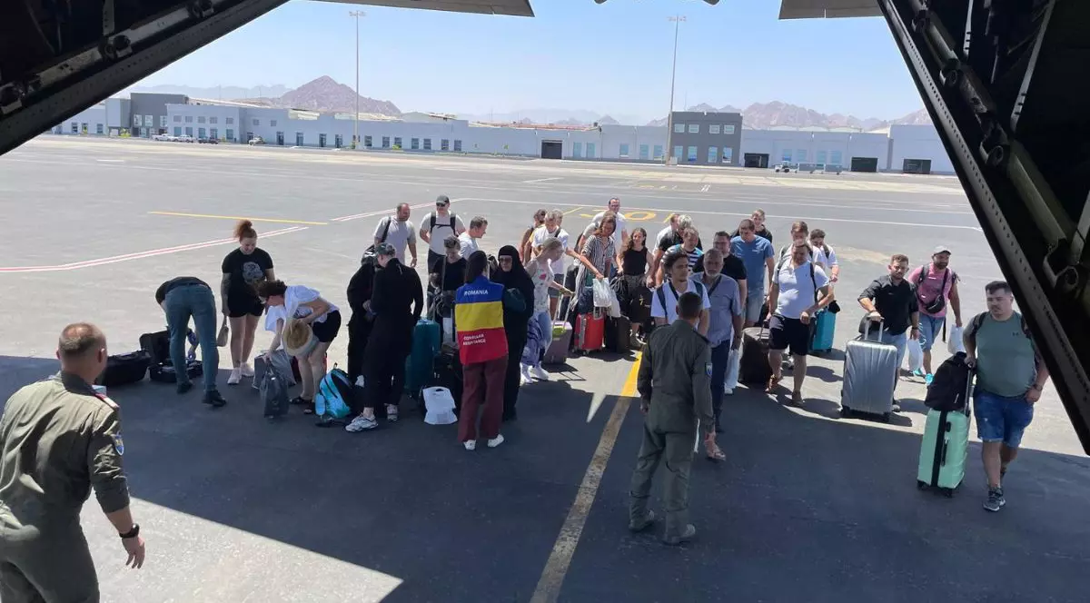 cetățeni români, fotografiați în fața unui avion militar, după ce au fost aduși în România din Iran