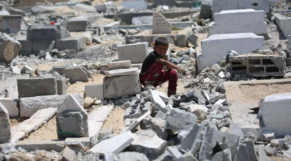 Copil stând singur printre grămezi de moloz, după un atac al armatei israeliene în Fâșia Gaza