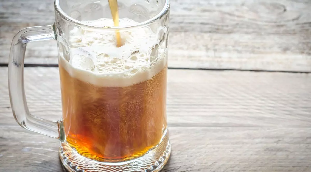 Halbă cu bere pe masa de lemn