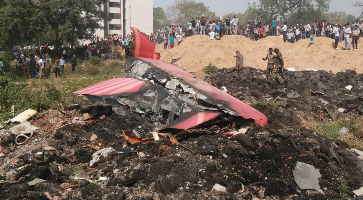 Oamenii privesc resturile unui avion Air India prăbușit în Ahmedabad, statul Gujarat din India, pe 12 iunie 2025.