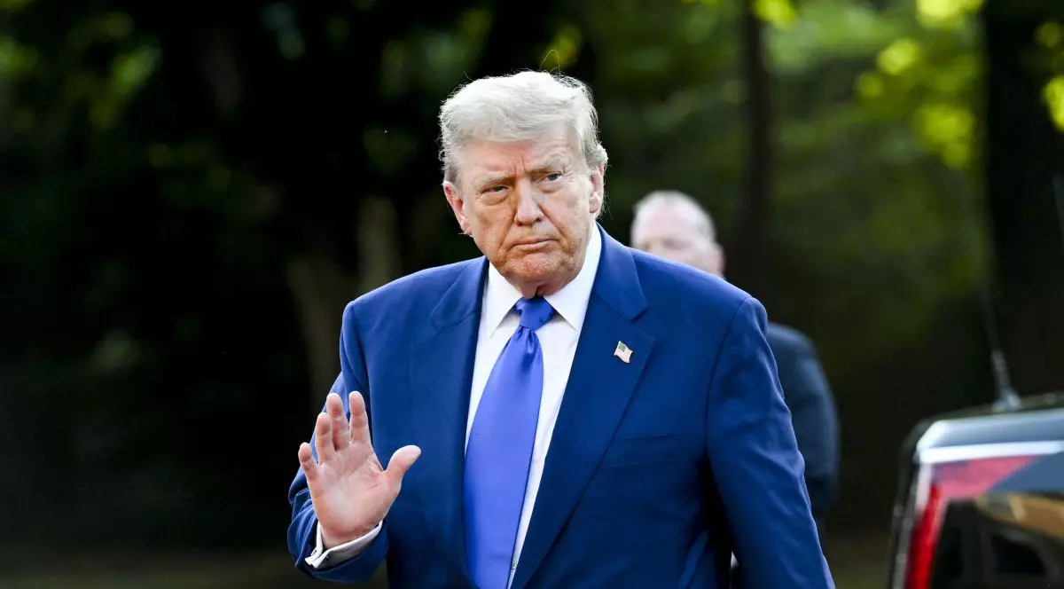 Donald Trump, îmbrăcat în costum albastru și cu o insingnă cu steagul SUA la rever, face cu mâna în timp ce sosește la summitul NATO de la Haga, Țările de Jos, 25 iunie 2025