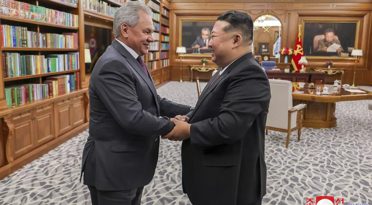 Kim Jong Un (dreapta) surprins în timp ce dă mâna cu Serghei Șoigu (stânga), în timpul vizitei la Phenian.
