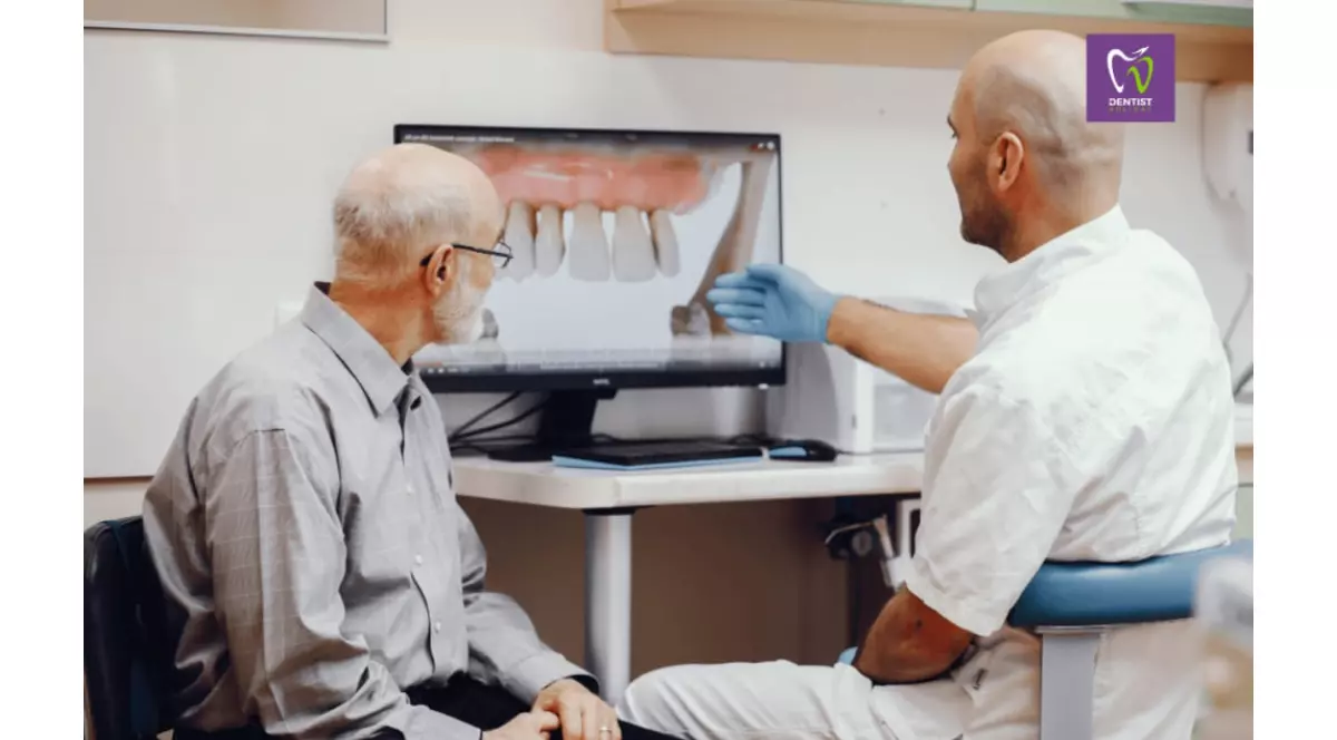 Barbat in varsta la dentist. Domnul doctor ii arata ceva pacientului pe laptop la o ecografie dentara