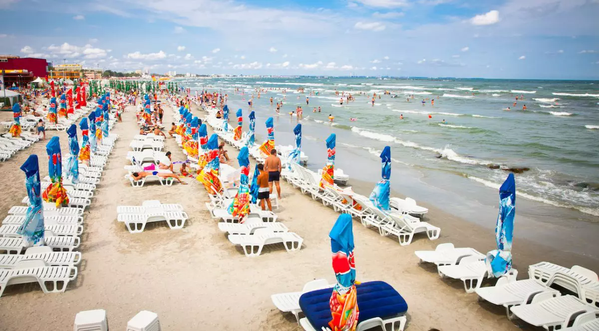 O plajă din Mamaia, România, cu umbreluțe și șezlonguri, iar oameni se văd în mare, 11 august 2012
