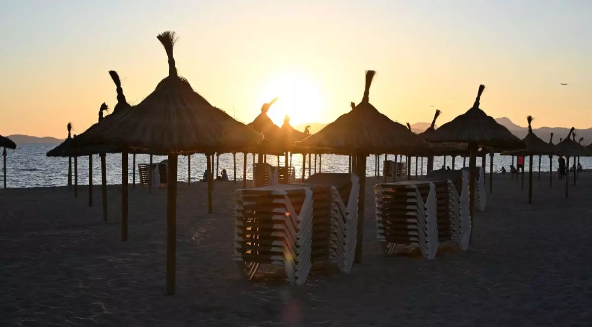 Imaginea arată plaja din Playa de Palma, umbrelă de soare, plajă cu nisip, șezlonguri, apus de soare, Mallorca