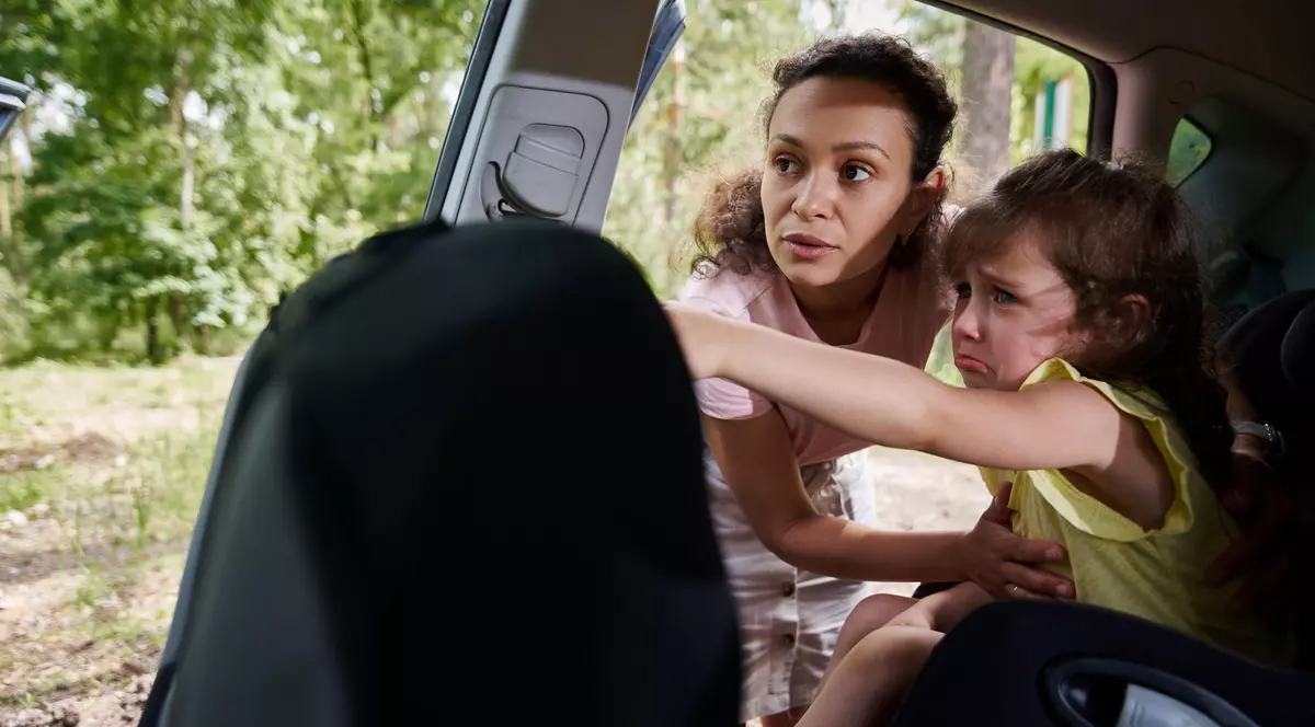 Femeie surprinsă în timp ce-și pune copilul în scaunul de mașină