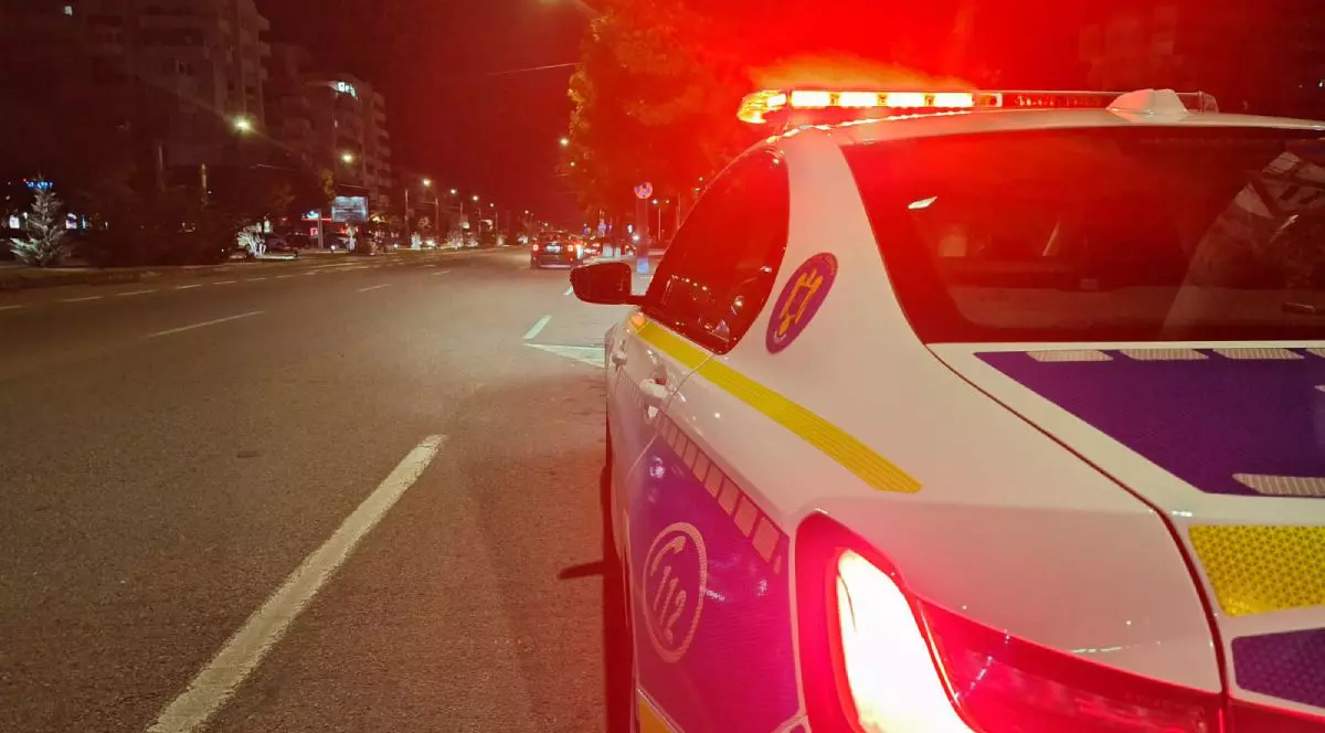 Mașină de Poliție Rutieră, din spate, noaptea, pe un bulevard din București, cu girofarul aprins, cu culoarea roșie