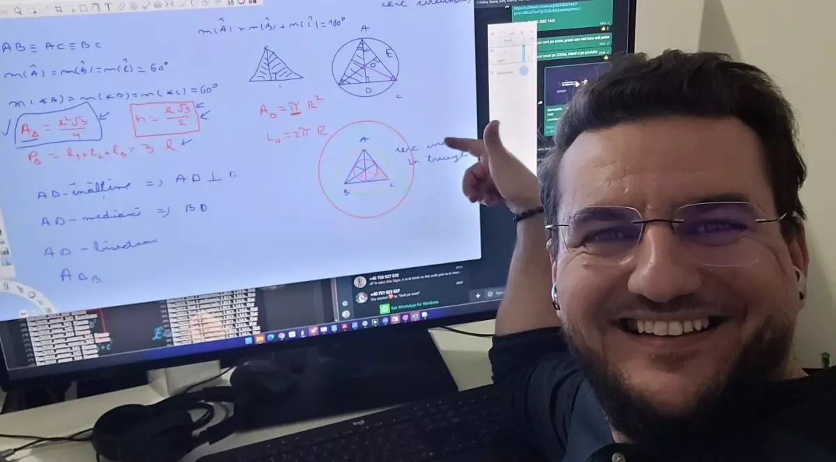 Bărbat care râde și arată cu mâna înspre un monitor de calculator