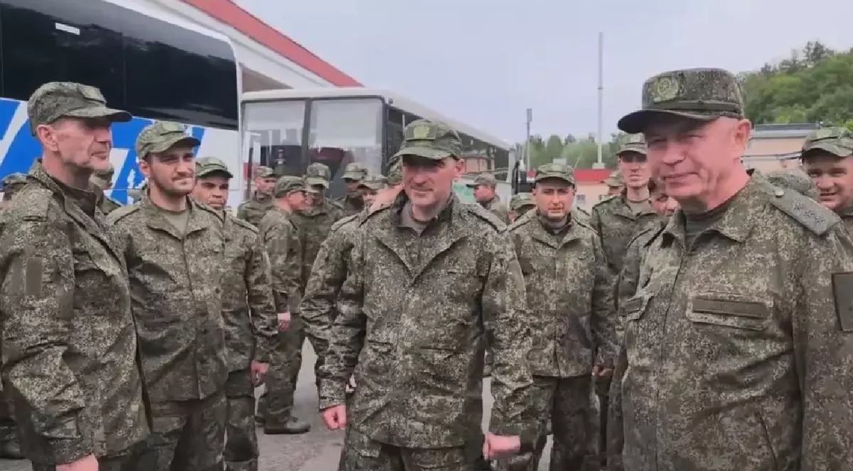 Mai mulți soldați, îmbrăcați în haine militare, afară