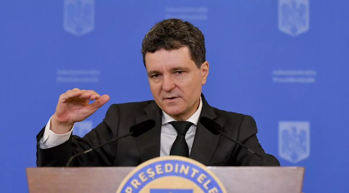 Președintele României Nicușor Dan susâine o conferință de presă și este cu mâna dreaptă ridicată
