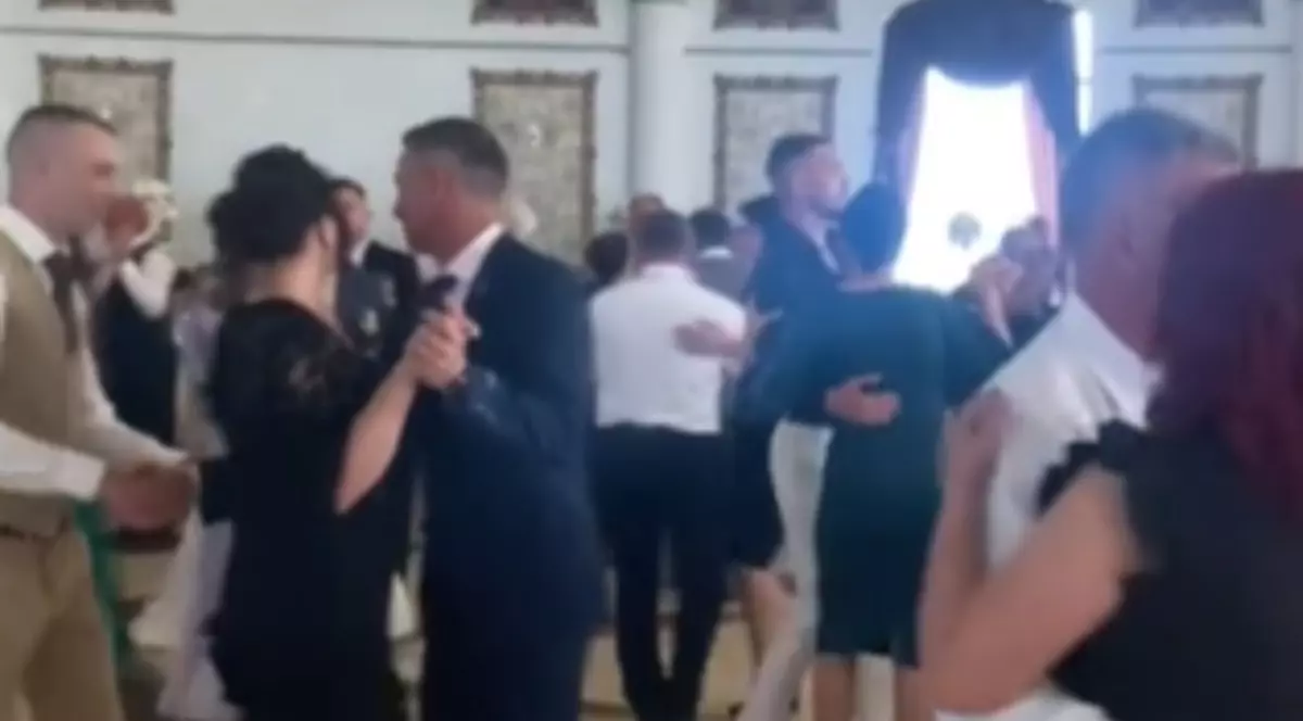 Oameni îmbrăcați elegant care se află la o nuntă și dansează
