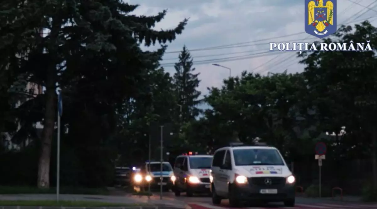 Imagini pe intuneric, masini de politie cu farurile aprinse, in misiune