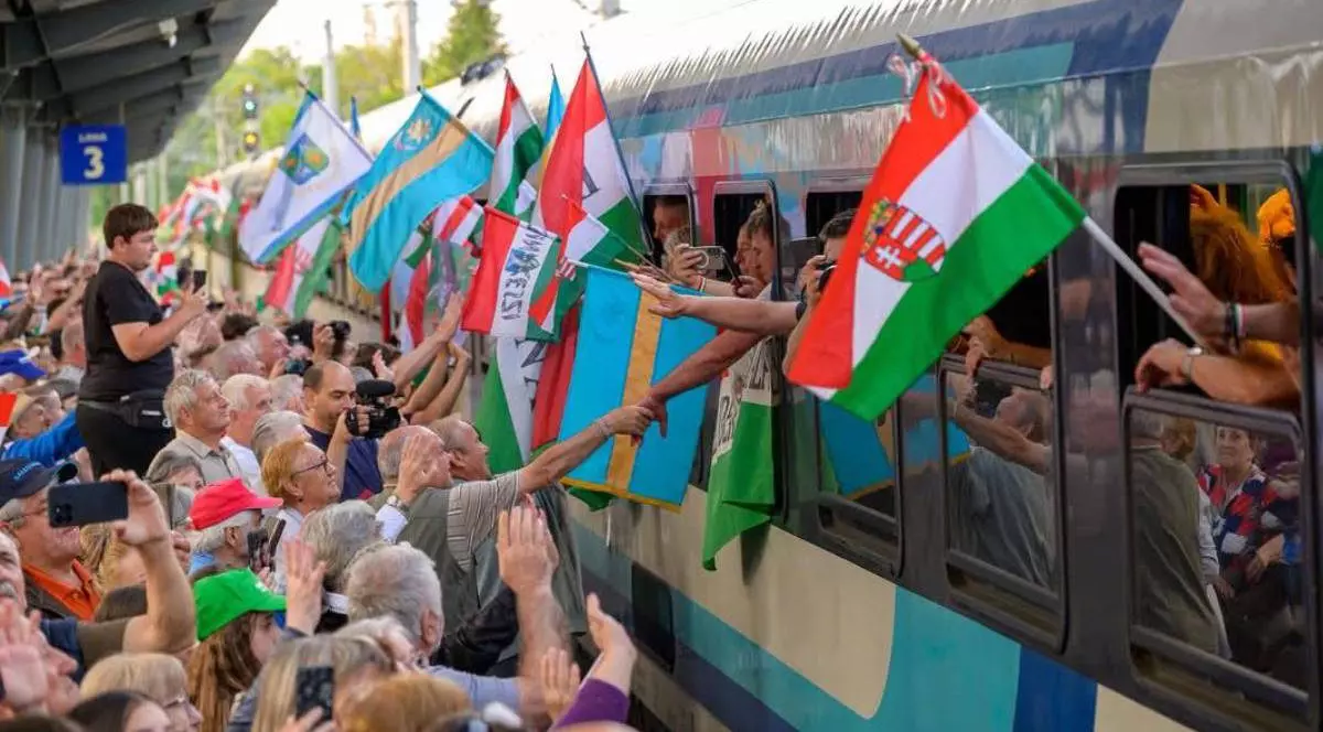 Poză cu oameni aflați în tren și cu alții pe peron