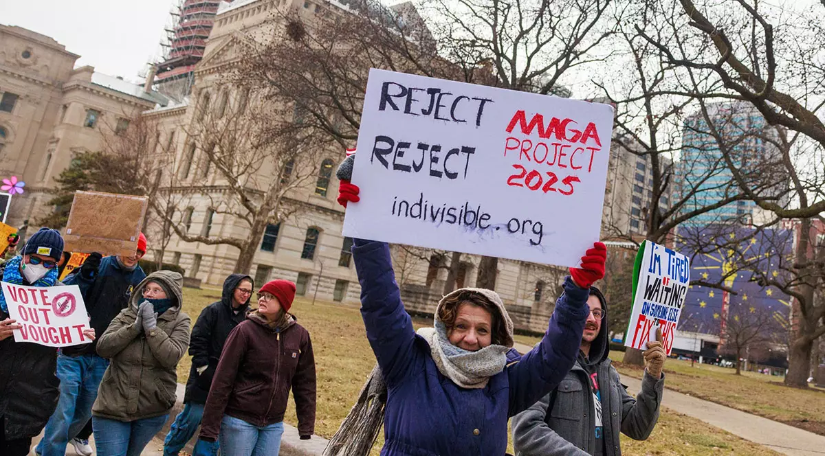 Un demonstrant ține o pancartă pe care scrie „Respingeți «proiectul MAGA 2025»”, în timpul unui protest anti-Trump la Reședința de Stat din Indiana, Indianapolis