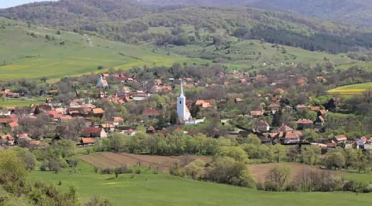 Imagine cu satul Crăciunel din Transilvania, ăn timpul verii. În imagine se distinge turnul alb al unei biserici