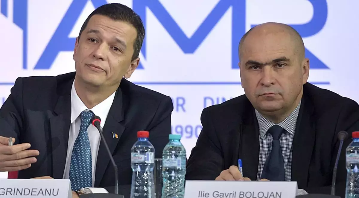 Președintele interimar al PSD, Sorin Grindeanu, și premierul desemnat Ilie Bolojan, stau unul lângă altul la masă, la o conferință de presă