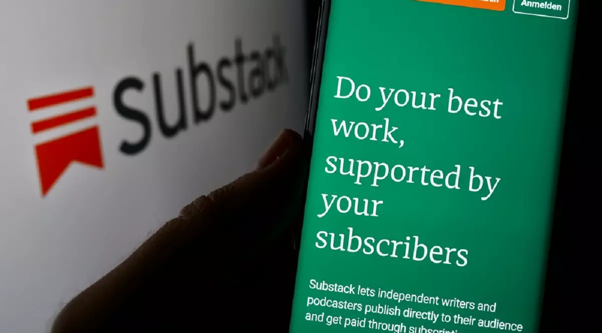 Ce este platforma Substack şi cum funcţionează - Imagine cu o persoană care ţine un smartphone în mână, lână un panou cu logo-ul Substack