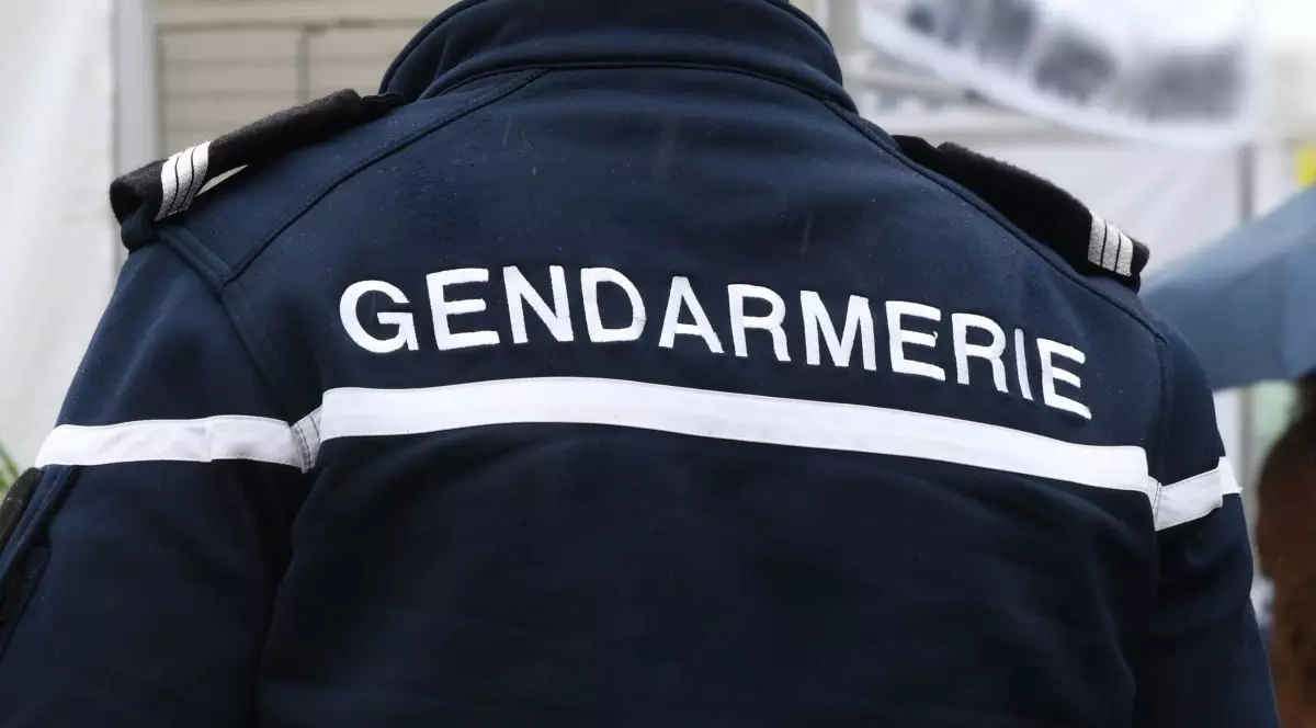 Spatele unui bărbat îmbrăcat în uniforma jandarmeriei, bleumarin cu alb, în Franța