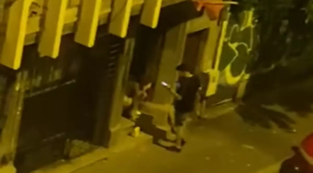 În imagine sunt ilustrați doi oameni care stau lângă un bloc, pe timpul nopții