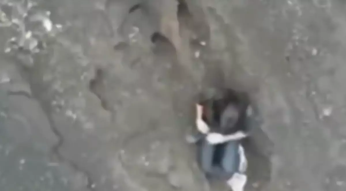 O femeie căzută într-un vulcan din Indonezia, surprinsă într-o poziție ghemuită.