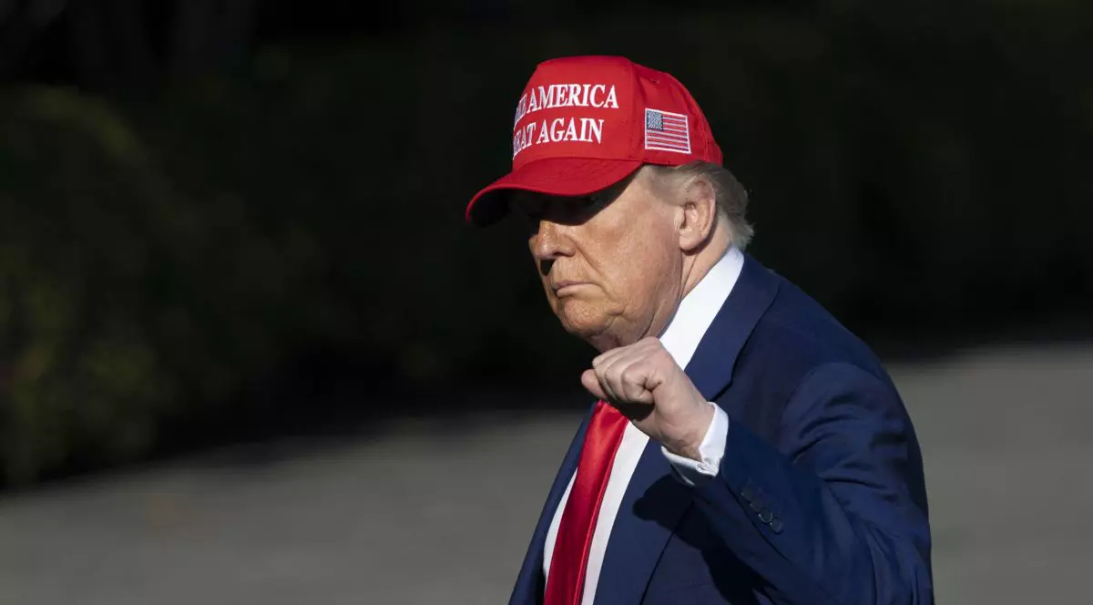 Președintele american Donald Trump poartă șapca având inscripționat mesajul „Make American Great Again” și ridică pumnul în semn de putere