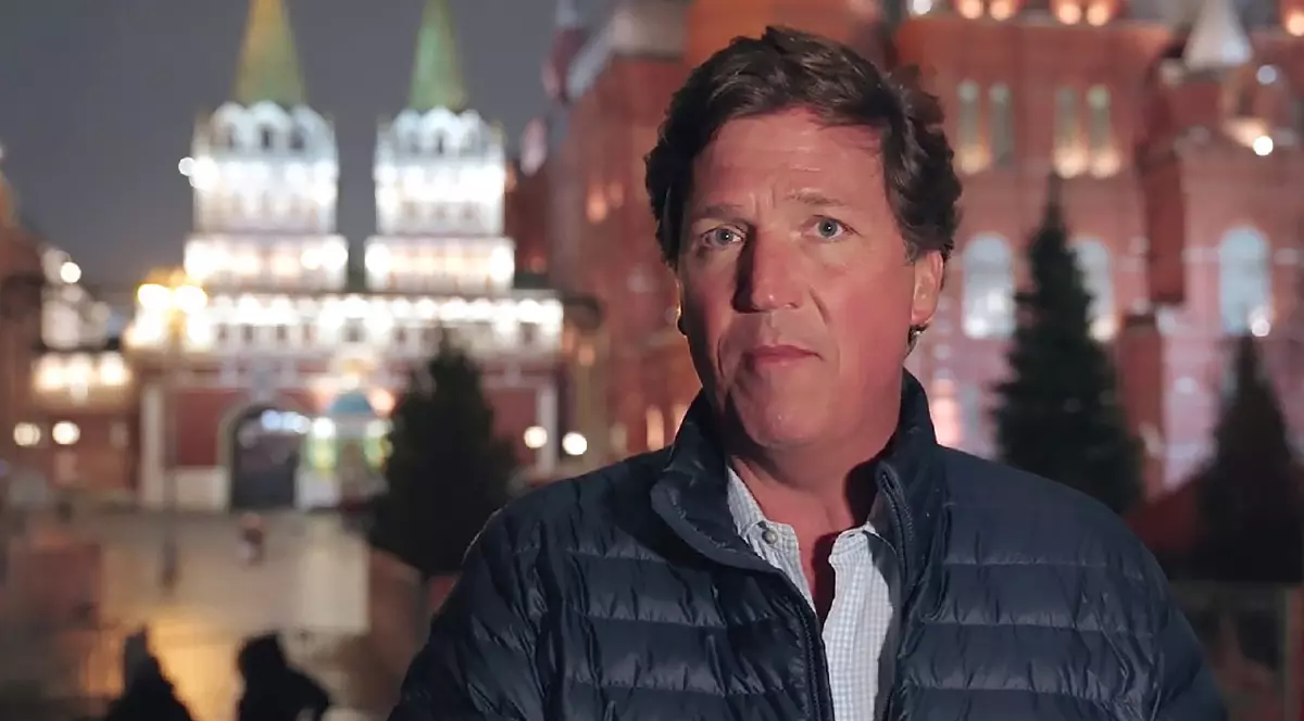 Tucker Carlson îmbrăcat într-o geacă albastră si o cămașă albă