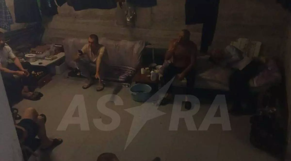 Imagine cu ucrainenii aflați în subsolul de la granița cu Georgia. În imagine sunt 3 bărbați, unul stă pe o canapea, iar ceilalți doi pe scaune