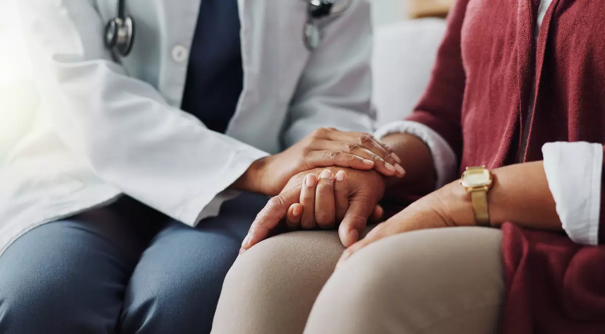 În imagine este ilustrat un doctor care ține mâna unei paciente