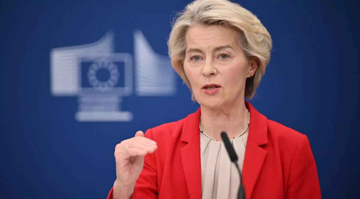 Președinta Comisiei Europene Ursula von der Leyen în timpul unei conferințe de presă, gesticulează cu mâna dreaptă și poartă un sacou roșu.