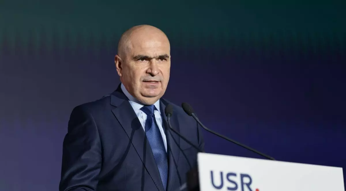 Aflat la un pupitru cu sigla USR, premierul desemnat Ilie Bolojan, îmbrăcat în costum bleumarin, susține declarații în fața membrilor partidului, sâmbătă, 21 iunie 2025.