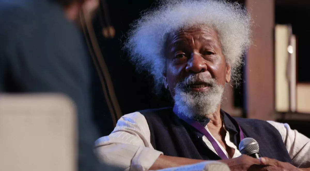 Wole Soyinka în timpul unui podcast, laureatul premiului Nobel stă pe fotoliu și vorbește la microfon