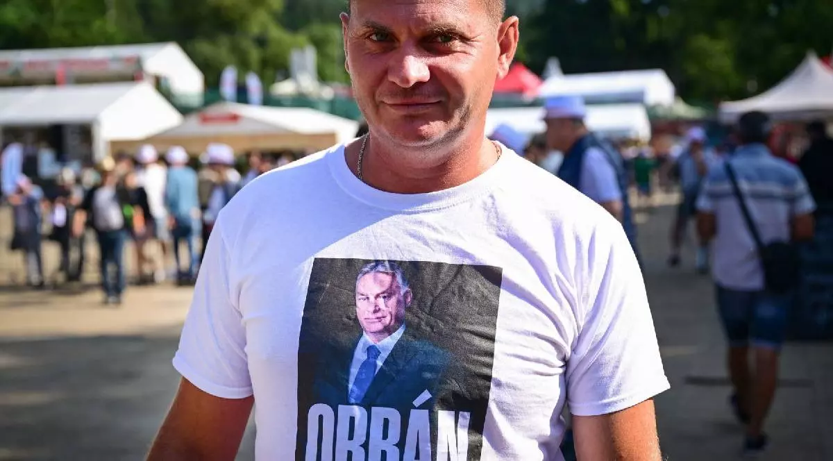 Un bărbat îmbrăcat cu un tricou cu fața lui Orban pe el