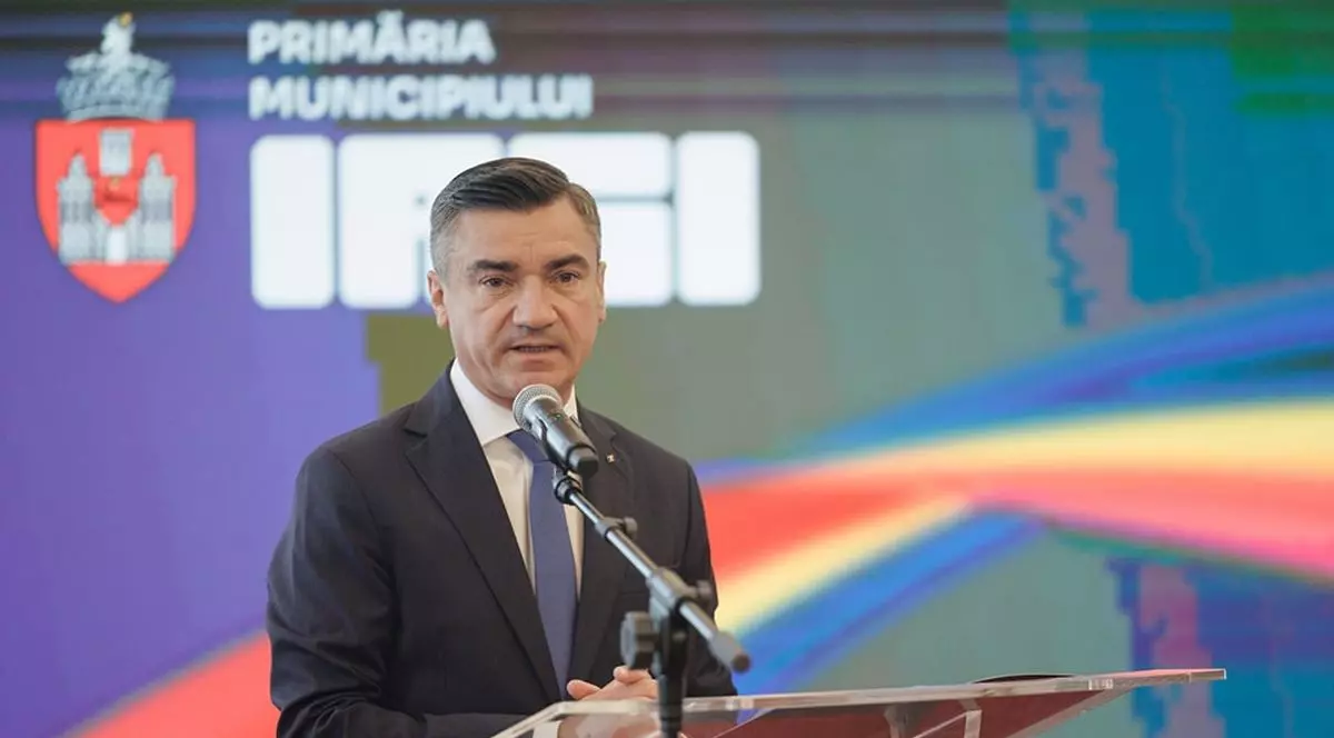 Mihai Chirica vorbește de la un pupitru, având în spate sigla municipiului Iași