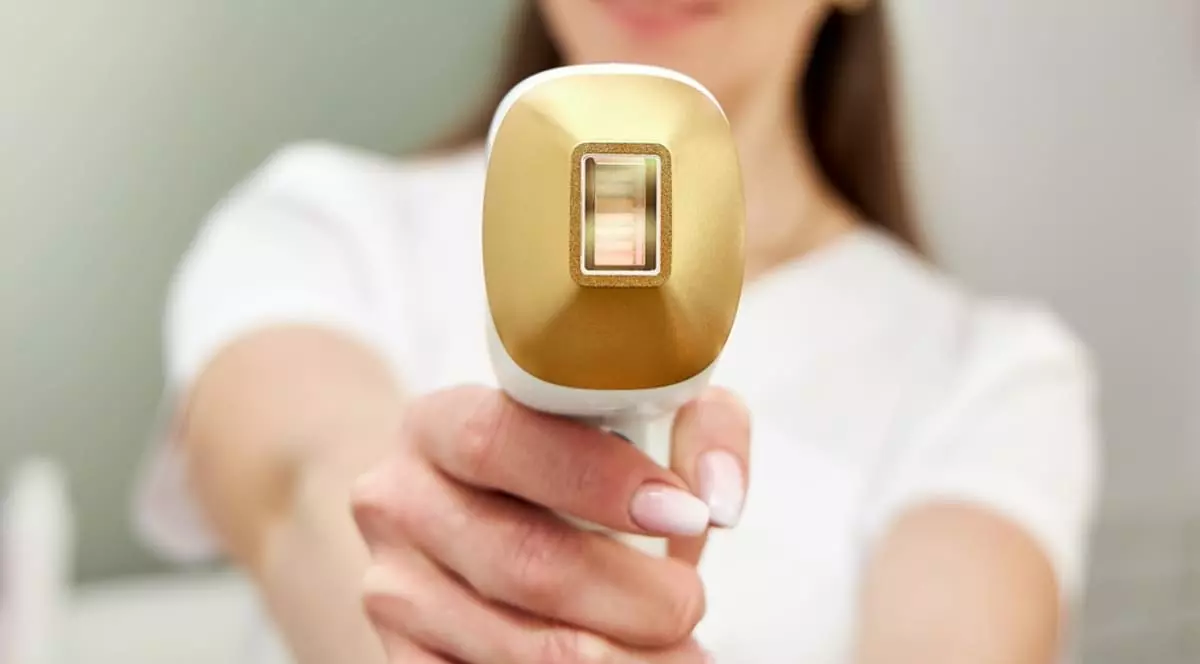 Femeie, tine in mana un aparat laser de epilare profesional