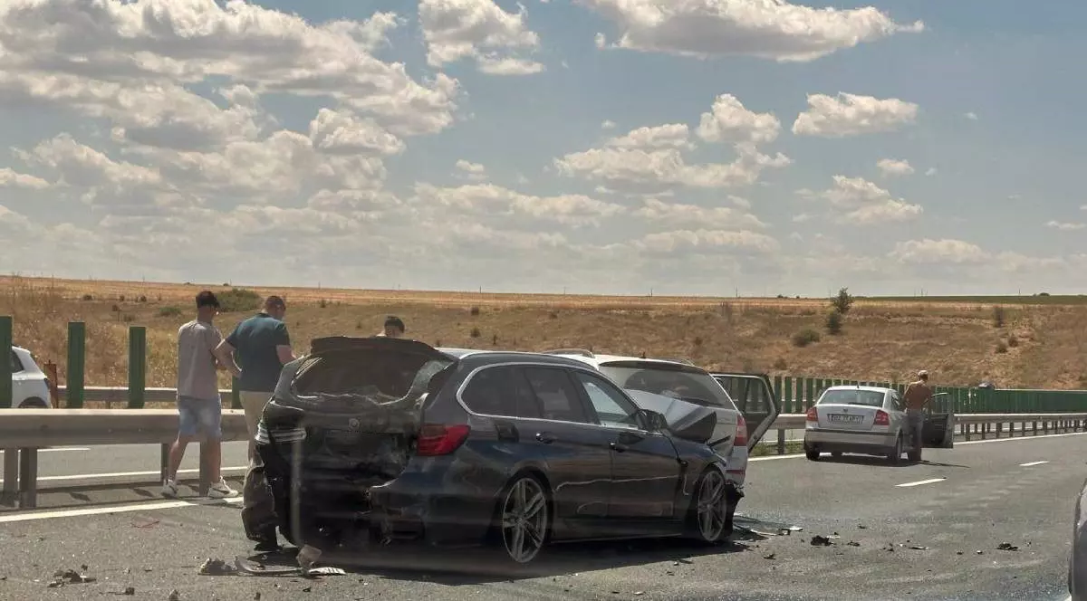 Imagine cu un BMW negru implicat în accidentul de pe A2 din 20 iulie 2025. Lângă vehicul se află trei bărbați, iar mai în față se află o altă mașină gri