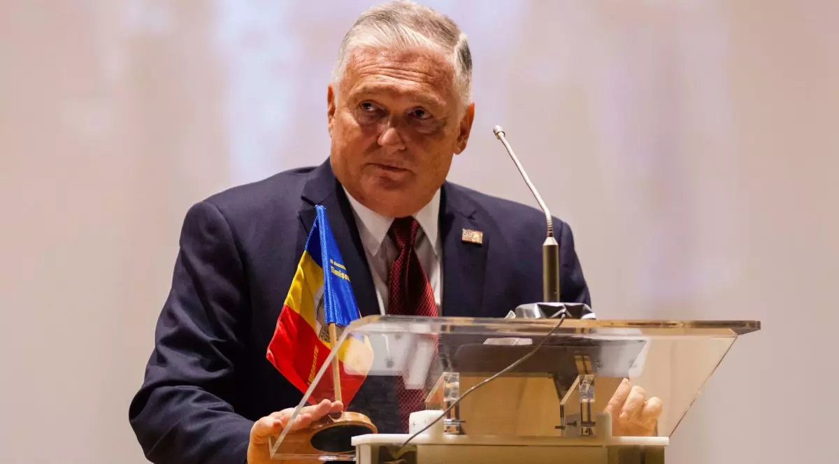 Adrian Zuckerman, fostul ambasador SUA in Romania, vorbește la microfon la un pupitru pe care se află steagul României la sedinta festiva a Consiliului Local Timisoara, organizata cu ocazia aniversarii a 31 de ani de la Revolutia din 1989, Sala Capitol, Timisoara, miercuri, 16 decembrie 2020.