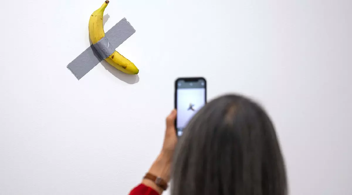Un vizitator admiră opera de artă „Comedian” a artistului italian Maurizio Cattelan în timpul vernisajului pentru presă al expoziției „Dimanche sans fin. Maurizio Cattelan et la Collection du Centre Pompidou”.
