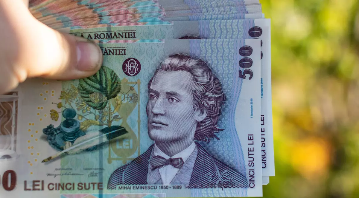 Imagine cu mai multe bancnote de 500 de lei ținute în mână de un bărbat