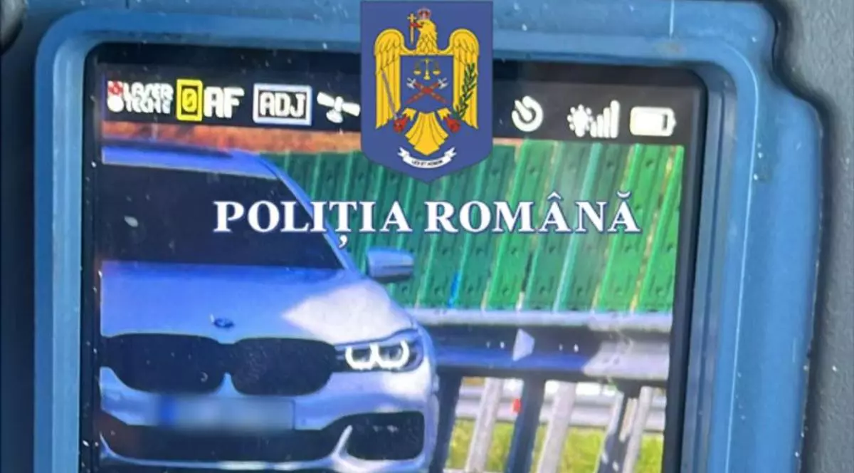 Imagine cu un aparat radar care surprinde un autoturism BMW de culoare gri care circulă pe un drum express din România