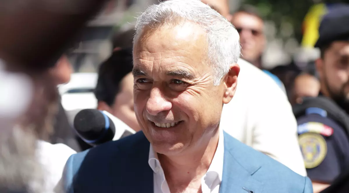 Călin Georgescu între susținători. in costum albastru si camasa alba, zambeste larg